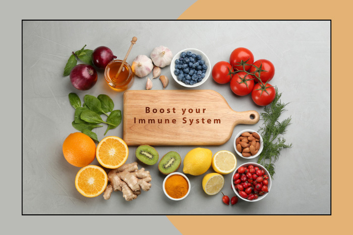 Fresh, colorful array of immune-boosting foods like citrus fruits, berries, nuts, and vegetables, with a cutting board stating 'Boost your Immune System', emphasizing natural health at HEAAL Homeopathy Clinic in Hyderabad.